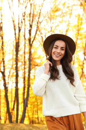 Beautiful happy woman wearing hat in park. autumn walkの写真素材