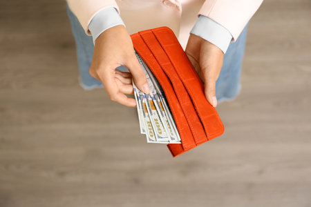Young woman holding wallet with dollar bills, top viewの写真素材