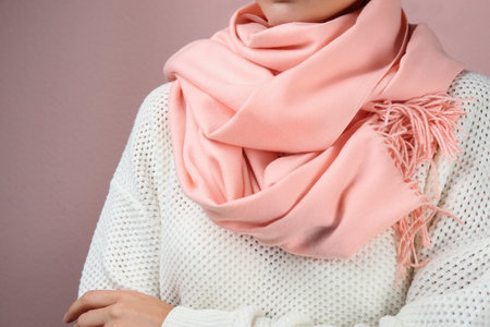 Woman wearing warm scarf on pink background, closeup. autumn clothesの写真素材