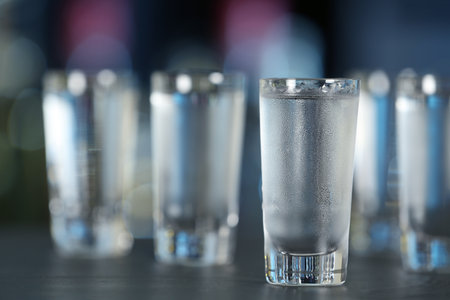 Shot of vodka on table against blurred background. Space for textの写真素材