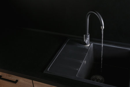 Close up view of water flowing from faucet indoors. Space for textの写真素材