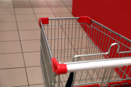 Empty metal shopping cart in supermarket, closeupの写真素材