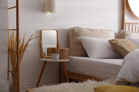 Stylish nightstand near bed in modern room interiorの写真素材