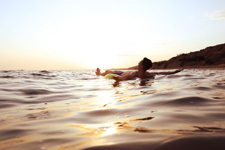 Young man with inflatable ring in the seaの写真素材
