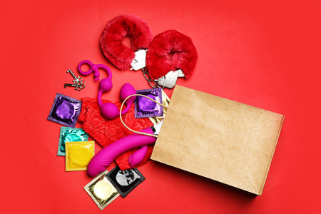 Shopping bag and different sex toys on red background, flat layの写真素材