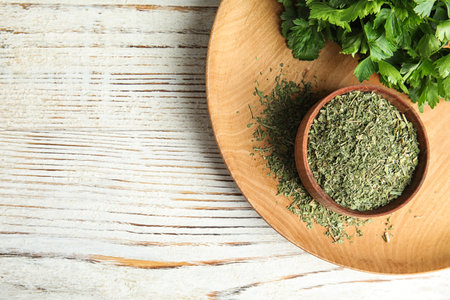 Flat lay composition with fresh and dried parsley on white wooden table. Space for textの写真素材