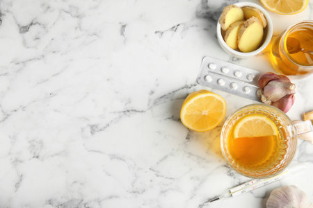 Flat lay composition with cold remedies on marble table, space for text. Sore throat treatmentの写真素材