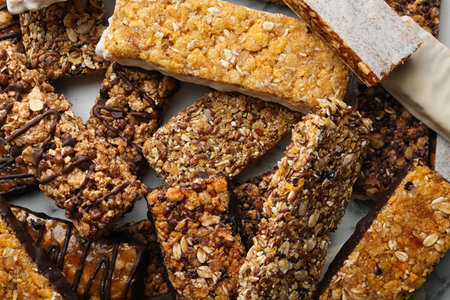 Healthy granola bars on white table, top view