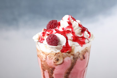 Tasty milk shake with topping on color background, closeupの写真素材