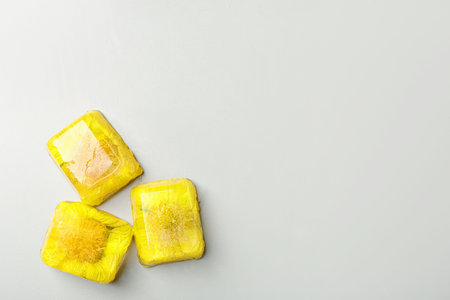 Ice cubes with flowers on light background, flat lay. Space for textの写真素材