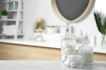 Cotton balls, swabs and pads on light gray table in bathroomの写真素材