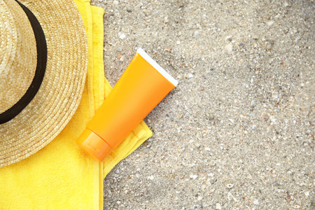 Flat lay composition with tube of sun protection body cream on sand beach, space for textの写真素材
