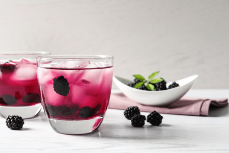 Delicious refreshing blackberry lemonade on white wooden table
