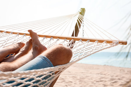 Young couple relaxing in hammock on beach, closeupの写真素材