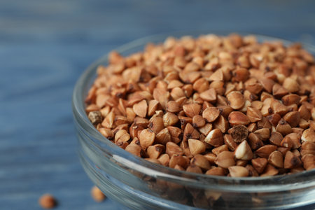 Uncooked buckwheat grains in glass bowl, closeupの写真素材