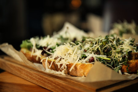Delicious bruschettas with beef and cheese on wooden table, closeupの写真素材