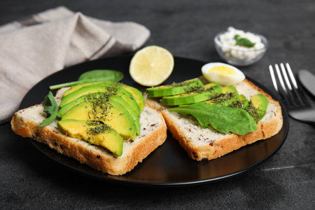 Tasty avocado toasts served on black table, closeupの写真素材