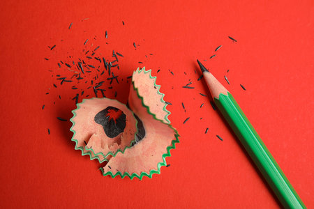 Pencil and shavings on red background, above viewの写真素材