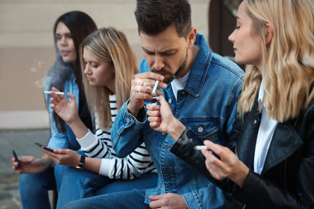 People smoking cigarettes at public place outdoors