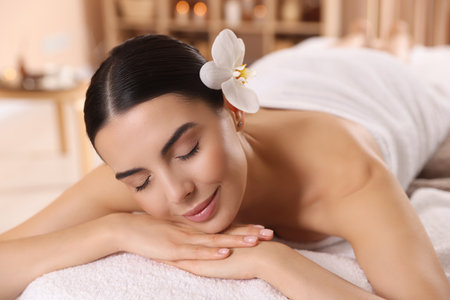 Young woman resting on massage couch in spa salonの写真素材