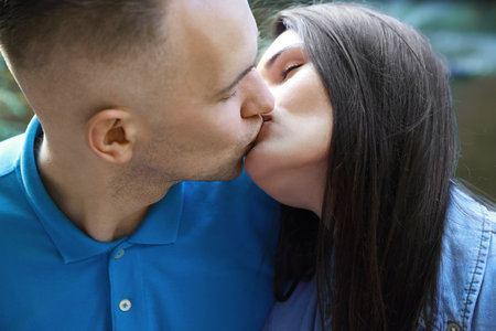 Affectionate young couple kissing outdoors, closeup viewの写真素材