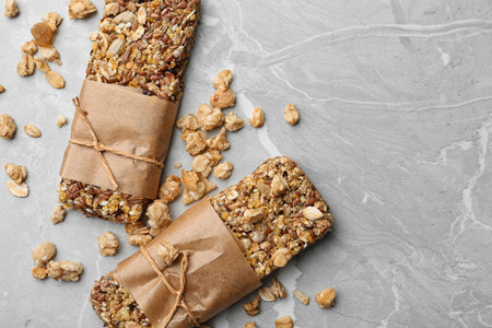 Healthy granola bars on gray table, flat lay. Space for textの写真素材