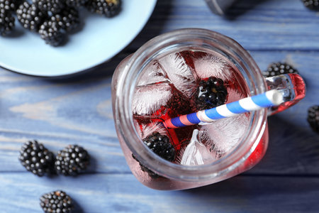 Flat lay composition with mason jar of blackberry lemonade on blue wooden tableの写真素材