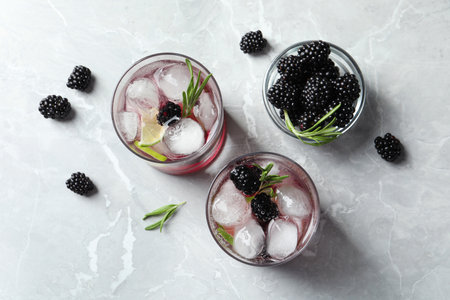 Flat lay composition with glasses of blackberry lemonade on light tableの写真素材