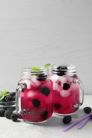 Delicious refreshing blackberry lemonade on table against light backgroundの写真素材