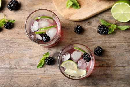 Flat lay composition with glasses of blackberry lemonade on wooden backgroundの写真素材