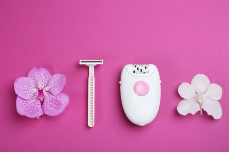 Modern epilator, razor and flowers on purple background, flat layの写真素材