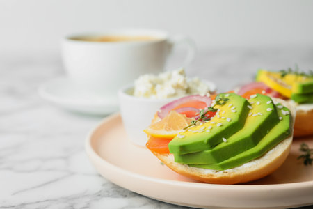 Plate of sandwiches with sliced salmon and avocado served on white marble tableの写真素材
