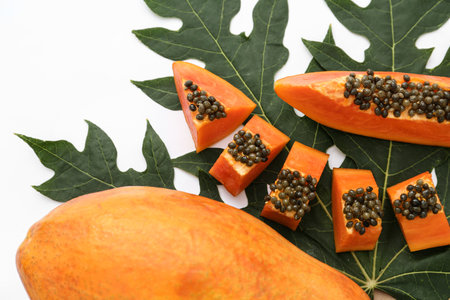 Fresh ripe cut and whole papaya fruits with leaf on white backgroundの写真素材