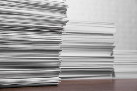 Stacks of white paper sheets on wooden table, space for textの写真素材