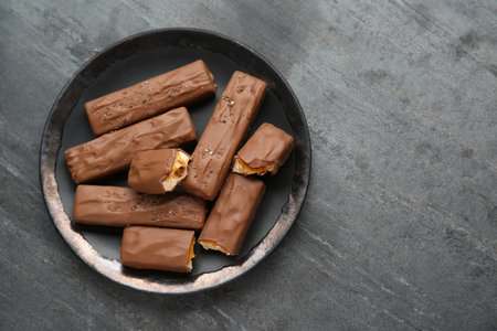 Plate with delicious chocolate bars on black table, top view. Space for textの写真素材