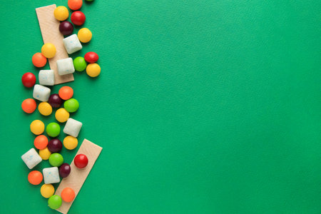 Different tasty chewing gums on green background, flat lay. Space for textの写真素材