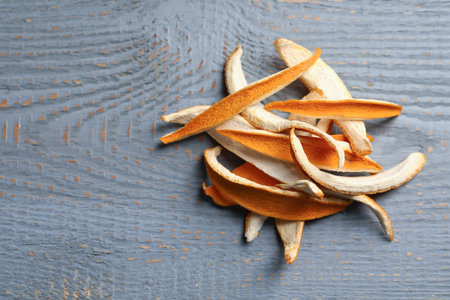 Dry orange peels on wooden table, flat lay. Space for textの写真素材