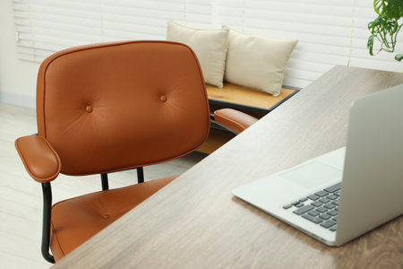 Comfortable office chair near desk at workplaceの写真素材