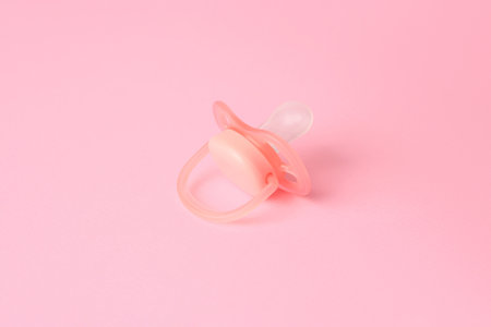 One new baby pacifier on pink backgroundの写真素材