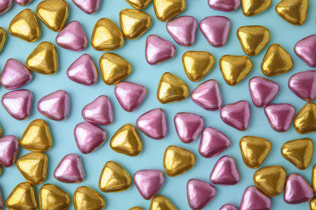 Many delicious heart shaped candies on light blue background, flat layの写真素材