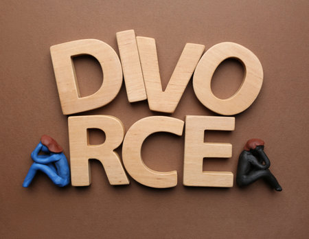 Word Divorce made of wooden letters and plasticine people figures on brown background, flat layの写真素材