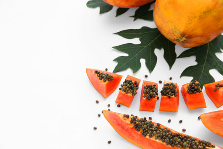 Fresh ripe cut and whole papaya fruits with leaf on white background. Space for textの写真素材