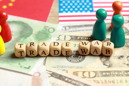 Wooden cubes with phrase Trade war on different banknotes near USA and China flags, closeupの写真素材