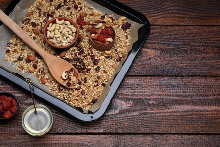 Tray with tasty granola, nuts and dry fruits on wooden table, flat lay. Space for textの写真素材