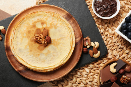 Delicious crepes with nuts and chocolate on table, flat layの写真素材