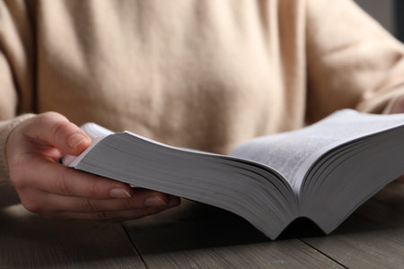 Woman reading Bible on wooden table, closeupの写真素材