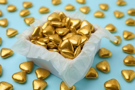 Box and delicious heart shaped candies on light blue background, closeupの写真素材