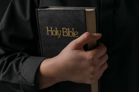 woman with holy bible on black background, closeupの写真素材