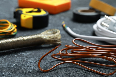Different electrical wires and tools on black textured table, closeupの写真素材