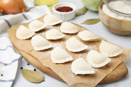Raw dumplings (varenyky) with tasty filling and ingredients on light gray tableの写真素材